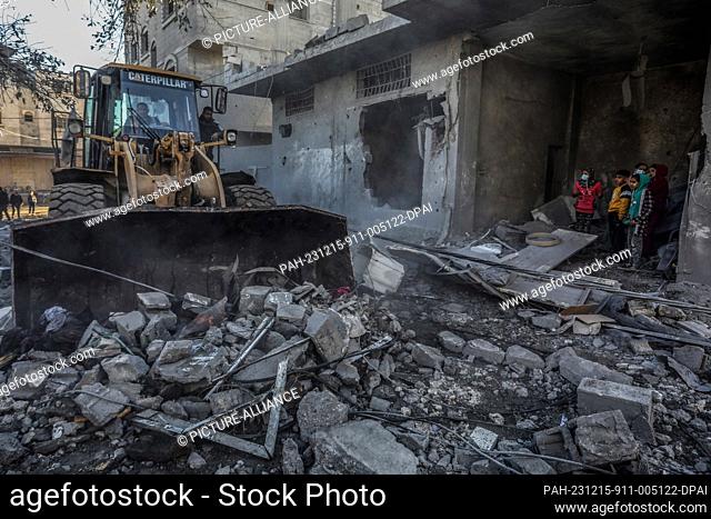 15 December 2023, Palestinian Territories, Rafah: Palestinians remove debris from damaged houses after Israeli air strikes on Rafah in the southern Gaza Strip