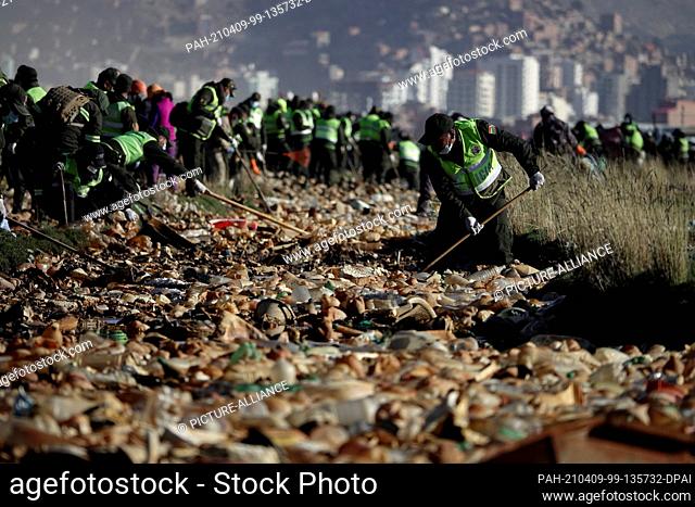 07 April 2021, Bolivia, Oruro: Members of the city authority take part in a large-scale cleaning operation at Lake Uru Uru