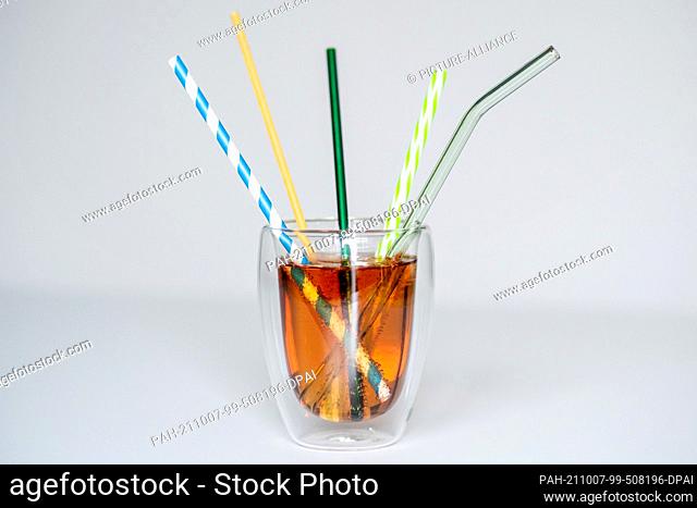 ILLUSTRATION - 01 October 2021, Lower Saxony, Oldenburg: A glass of lemonade with several reusable drinking straws made of paper, stainless steel