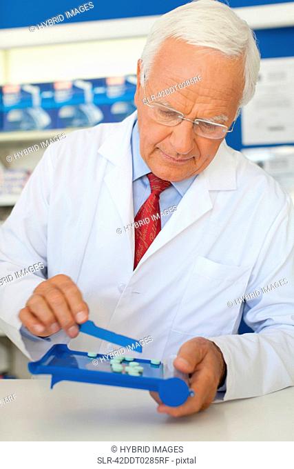 Pharmacist counting pills at counter