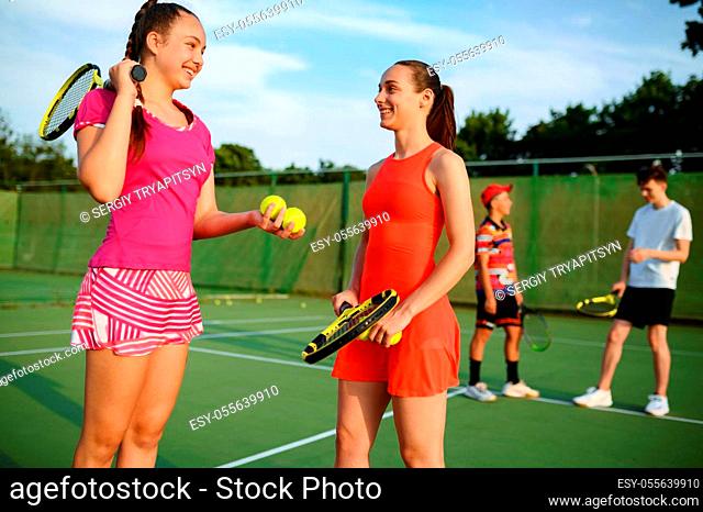 Mixed doubles tennis, happy players after game, outdoor court. Active healthy lifestyle, sport with racket and ball, fitness workout with racquets