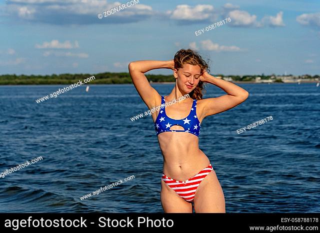 A beautiful dark blonde bikini model enjoys the weather outdoors on the beach