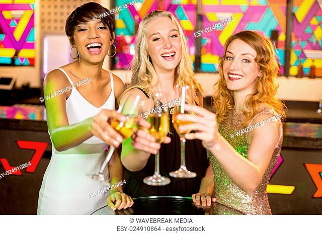 Three smiling friend toasting glass of champagne