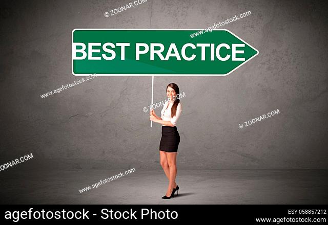 Young business person in casual holding road sign with BEST PRACTICE inscription, new business direction concept