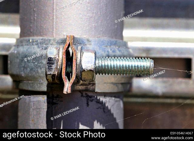 metal parts and racks with tubes connected by means of fastening system by means of bolts covered with rust