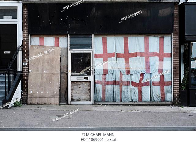 English flags covering abandoned storefront, Margate, England