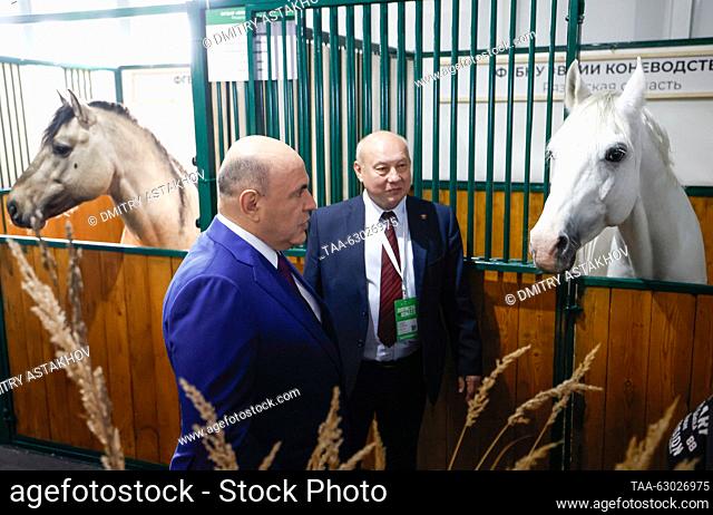 RUSSIA, MOSCOW - OCTOBER 5, 2023: Russia's Prime Minister Mikhail Mishustin (L) visits a horse stable ahead of a plenary session as part of the 2023 Golden...