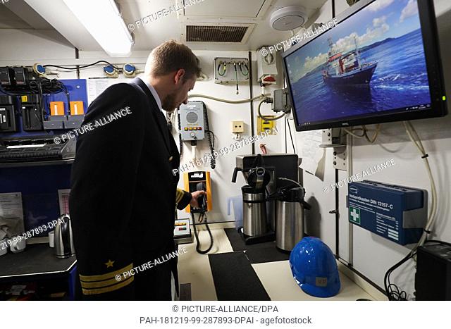 19 December 2018, Hamburg: A crew member calls the onboard telephone on the research vessel ""Meteor"" during a press tour