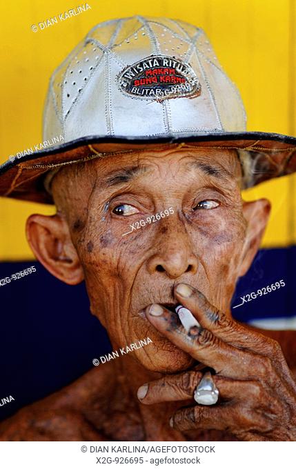 A skinny elderly man smoking cigarette, Semarang, Central Java, Indonesia
