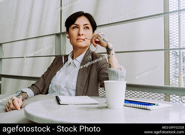 Thoughtful freelancer with eyeglasses sitting in cafe