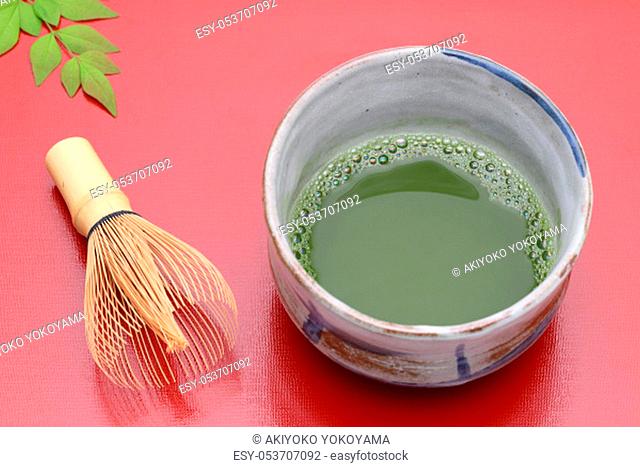 Japanese matcha green tea in a ceramic bowl with tea whisk