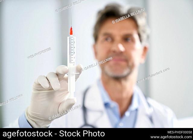 Doctor holding syringe in his medical practice