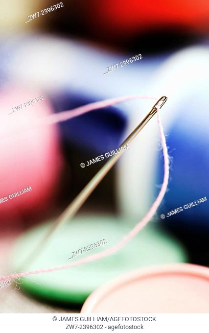 Needle threaded with pink cotton