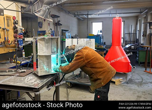 14 December 2022, Rhineland-Palatinate, Weisel: Andre Heller welds together a radar reflector for a floating shipping sign at the Weisel buoy factory