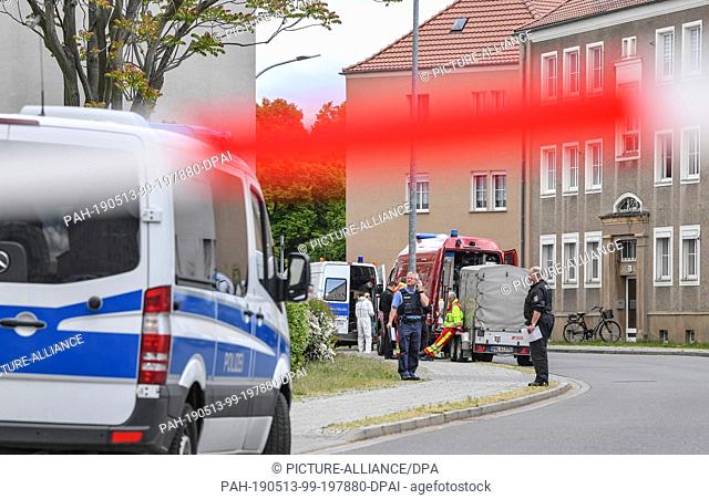 13 May 2019, Brandenburg, Forst: Police officers and forensic technicians are standing in the closed Amtstraße. Two male corpses have been discovered in an...