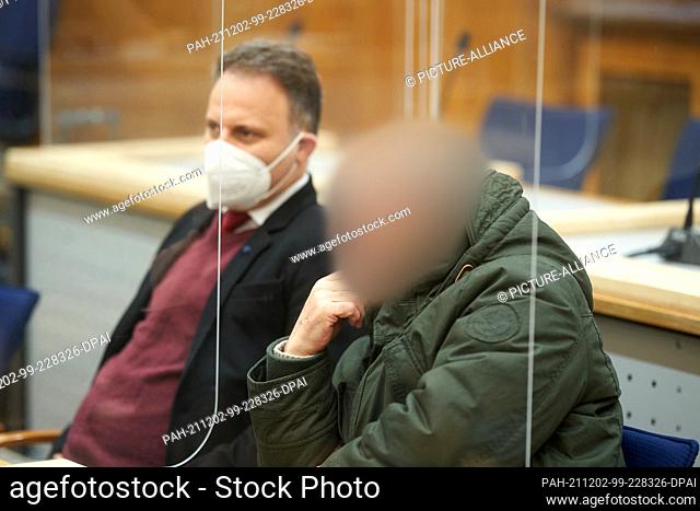 02 December 2021, Rhineland-Palatinate, Koblenz: The defendant (r) waits in the courtroom of the Higher Regional Court for the trial to begin
