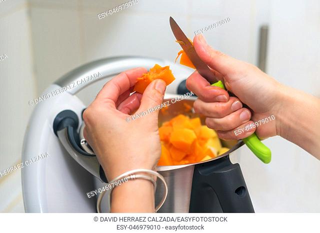 woman hands Preparing pumpkin puree in cook machine