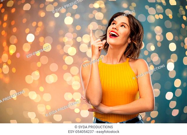 happy smiling young woman pointing finger up