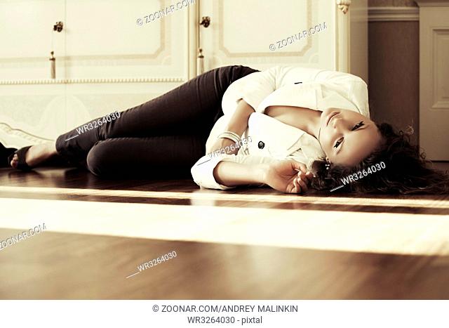 Sad beautiful fashion woman lying on the floor
