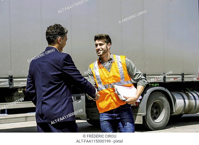 Worker and businessman shaking hands