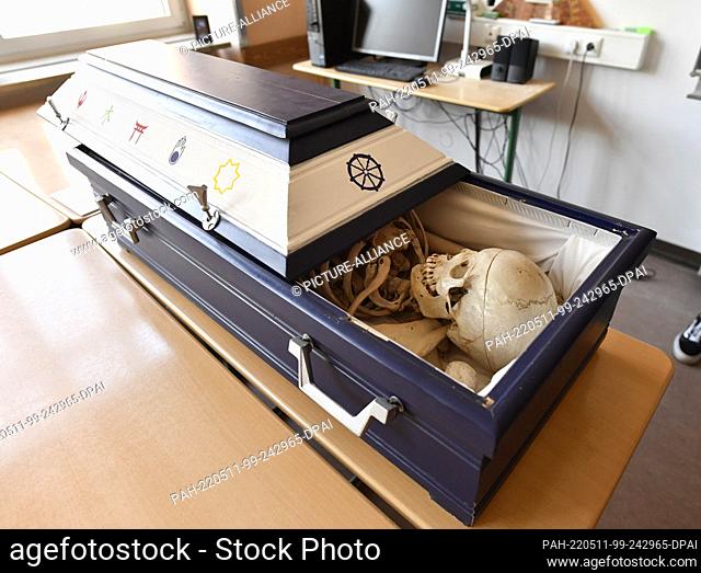11 May 2022, North Rhine-Westphalia, Schleiden: The coffin with the bones of a school skeleton is laid out in the biology class just before the students carry...