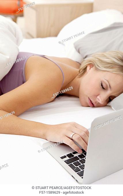 Young woman fallen asleep while on her laptop