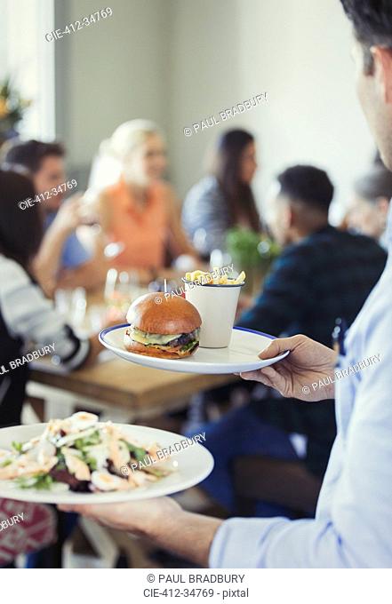 Waiter serving food in restaurant