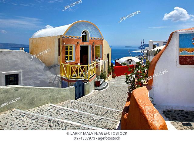 Colorful store and stone steps leading down path with ocean view in Oia, Santorini, Greece