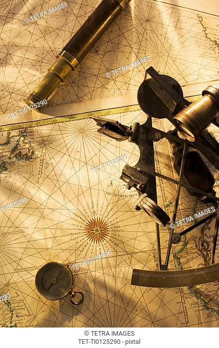 Octant, compass and telescope on nautical map