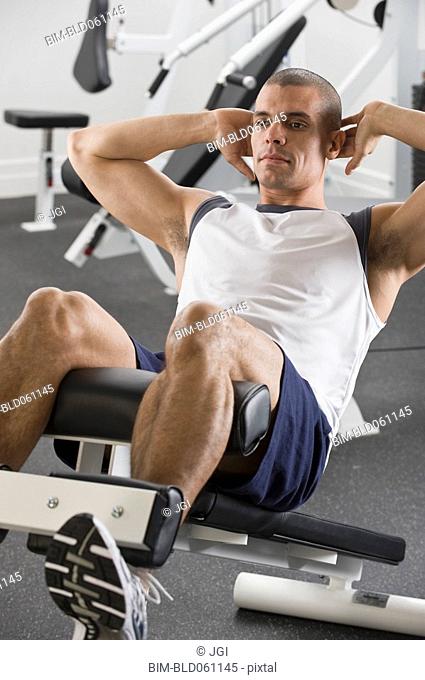 Hispanic man exercising in gym
