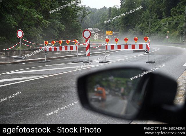 18 July 2021, Bavaria, Königssee: A barrier is seen on the road towards Ramsau, which was closed, during severe weather and flooding in Bavaria's...
