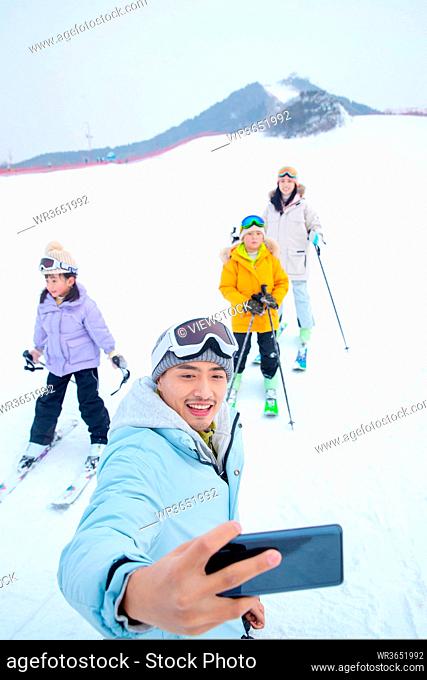 Skiing field using a mobile phone take a family of four