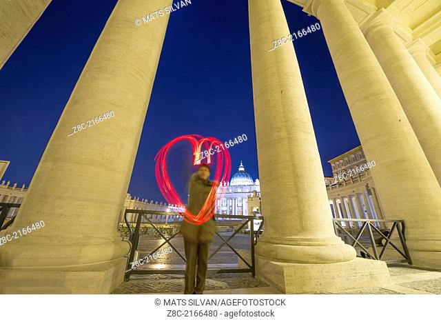 Woman light painting a heart in Vatican City In Rome, Italy