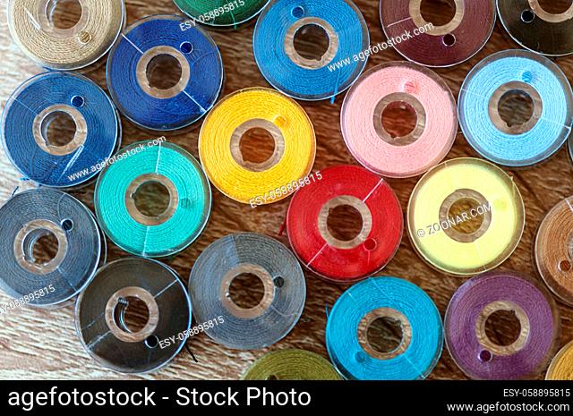 Close-up on colored sewing threads on spools. Top view