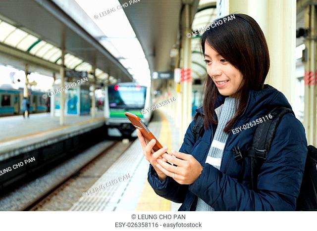 Woman use of mobile phone at train station