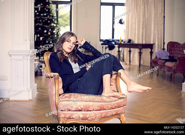 Girl on antique armchair in city villa in Germany