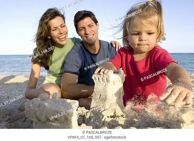 Parents making a sand castle with their son and daughter