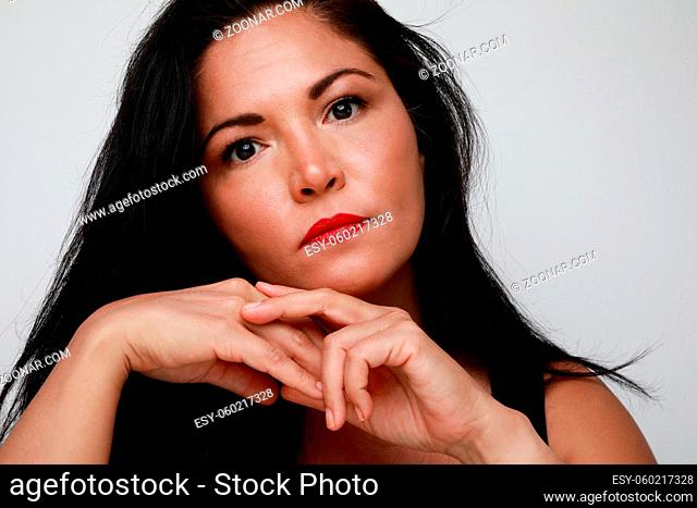 Pretty thoughtful woman with serious expression. Close-up. High quality photo