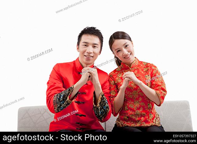 Portrait of young couple in Tang suits, paying New Year call high quality photo