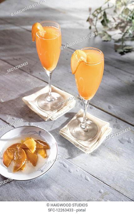 Whiskey cocktail in champagne flute with macerated peaches garnish