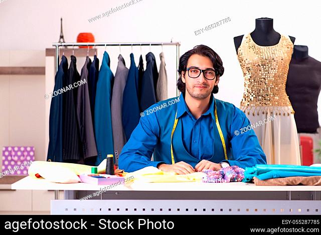 Young male tailor working at workshop