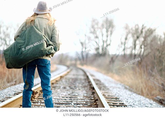 Woman with seabag on the rail road tracks