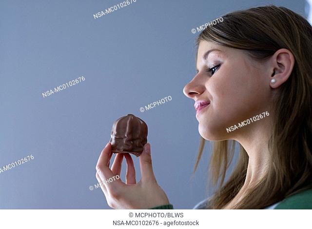 young woman with a chocolate marsmallow in her hand
