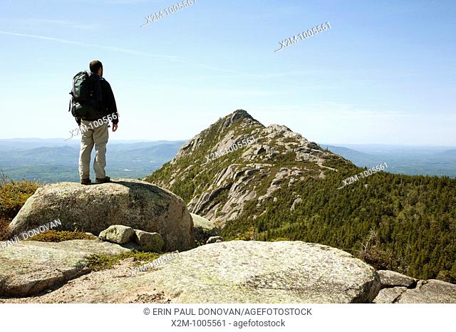 A hiker takes in the view of Mount Chocorua from Middle Sister Trail during the spring months  Located in the White Mountains, New Hampshire USA