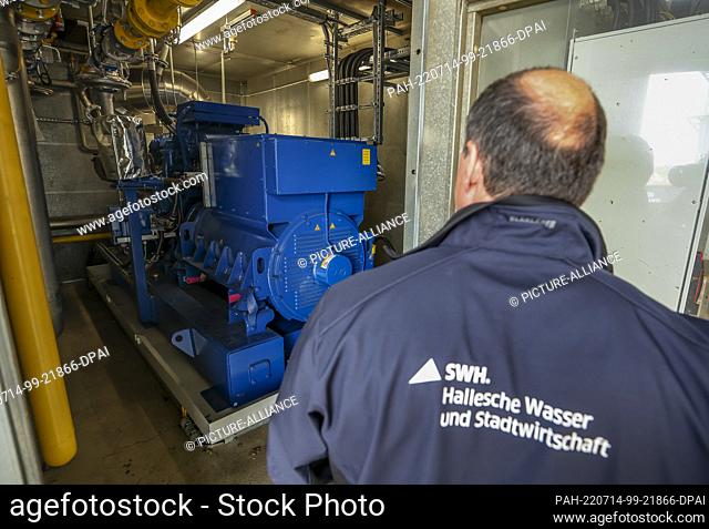 14 July 2022, Saxony-Anhalt, Halle/Saale: An employee of Hallesche Wasser und Stadtwirtschaft (HWS) stands in one of three combined heat and power plants that...
