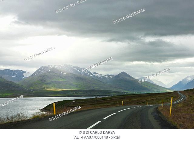 Iceland, road through tranquil countryside with mountains in background