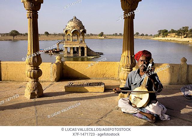 Musician in Gadi Sagar, the tank was once the water supply of the city and is surrounded by small temples and shrines, Jaisalmer, Rajasthan, India