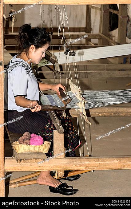 Junge Frau webt an einem traditionellen Lao-Thai Webstuhl, Ban Phanom, Laos / Young woman weaving on a traditional Lao-Thai style loom, Ban Phanom, Laos