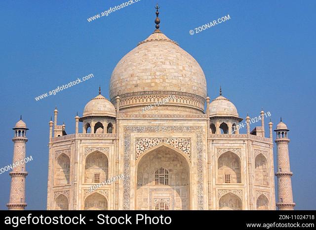 Close view of Taj Mahal against blue sky, Agra, Uttar Pradesh, India. It was commissioned in 1632 by the Mughal emperor Shah Jahan to house the tomb of his...