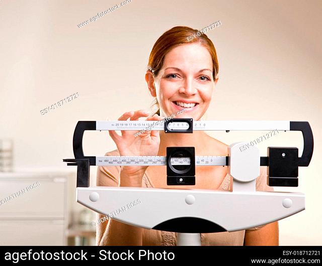Woman weighing herself in doctor office